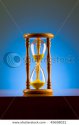 stock-photo-time-concept-with-hourglass-against-background-45658021.jpg